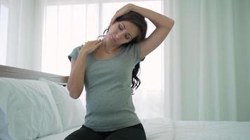 donna incinta che fa esercizio di stretching dopo essersi svegliata la mattina in camera da letto video