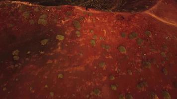 vídeo de drone de uma pessoa no topo de um vulcão durante o pôr do sol.