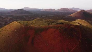 vista drone della cima di un vulcano rosso in un parco naturale in spagna.