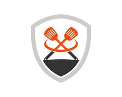 Simple shield with cross barbeque spatula inside vector