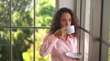 vacker latinsk kvinna som dricker kaffe på morgonen video