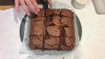 cutting chocolate brownies cake on plate video