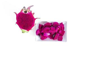 dragon fruit cut into small pieces served on a white plate isolated on a white background. top view photo