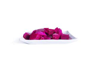 Dragon fruit cut into small pieces served on a white plate isolated on a white background. photo