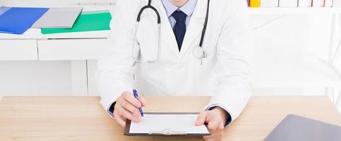 Portrait of senior doctor in medical office.Man in white uniform photo