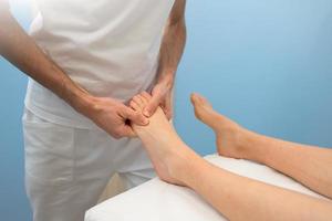 Treatment and foot massage by a professional physiotherapist photo