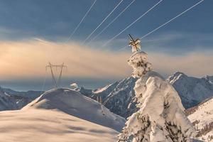 High voltage pylons on snowy mountains photo