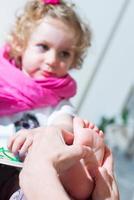 Reflexology foot massage to a female child photo