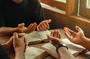 los jóvenes cristianos se unen en oración y buscan las bendiciones de Dios. leyendo la Biblia y compartiendo el alféizar de la ventana del evangelio foto