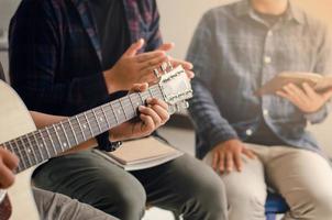 Young men play the guitar, praise God with music, and worship God together in a Christian family. Friendship is a Christian concept.