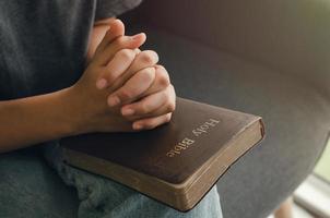 A young woman sits in prayer to communicate with God and the Bible. Religious with prayer bible photo