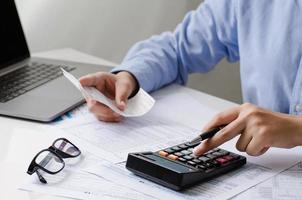 Man calculates bills on home income Use the modern office balance and expense calculator. Businessman making paperwork to pay taxes, expenses, accounting, tax concept.