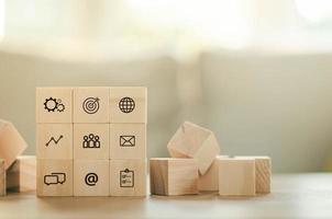 Arrange overlapping wooden blocks with business leaders icons. Key success factors include the world, thought box, inbox, email, internet, goals, preferences, people, business, and statistical graphs.