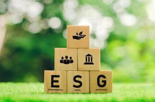 Environmental conservation and sustainable modernization of ESG using renewable resource technologies to reduce pollution. icon on wooden block green background photo