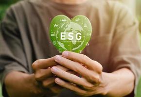 earth day concept Green Energy ESG is in the palm of your hand with a heart-shaped leaf for environment, society and governance. Renewable and sustainable resources Caring for the environment