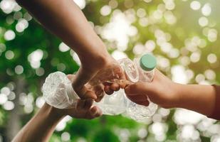 eliminar residuos para conservar un mundo mejor con buen medio ambiente y atmósfera natural de la mano como un equipo, unidad, sosteniendo las botellas de plástico juntas. reducir el calentamiento global salvar el mundo foto