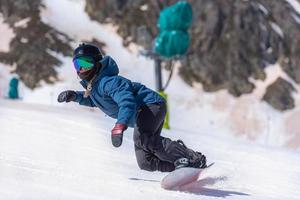 mujer joven, snowboarder, en movimiento, en, snowboard, en, montañas foto