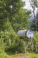 Depósito de gasolina o dispensador de agua en el prado en Noruega. foto