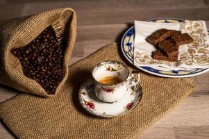 coffee cup with coffee grains and biscuits photo