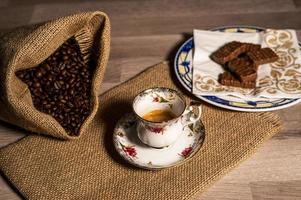 taza de café con granos de café y galletas foto