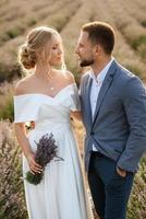 la novia y el novio en el campo de lavanda foto