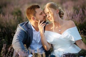 la novia y el novio en el campo de lavanda foto