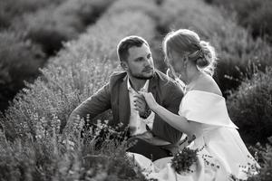 la novia y el novio en el campo de lavanda foto