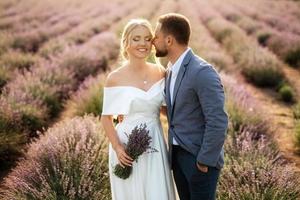 la novia y el novio en el campo de lavanda foto