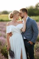 bride and groom on in the lavender field photo