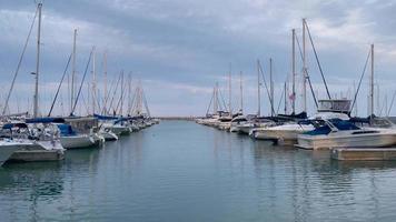 barche nel porto turistico, uno scatto di yacht nel porto del lago michigan, kenosha, wisconsin, gli stati uniti in una tranquilla giornata estiva con barche a vela attraccate e un muro di tempesta alla fine. video