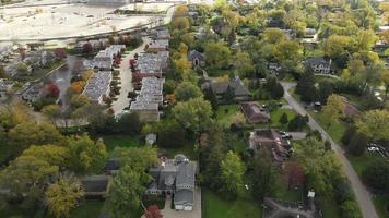 Aerial view of residential neighborhood in Northfield, IL. Lots of trees starting to turn autumn colors. Large residential homes, some with solar panels. Meandering streets video