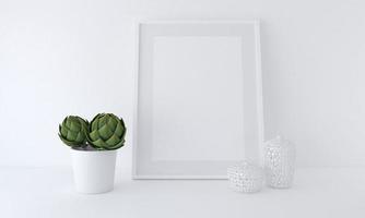 Representación 3D de una maqueta de marco en blanco junto a una planta en maceta apoyada contra una pared blanca foto