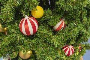 Happy New Year Christmas tree decorates on background bokeh of side flickering light bulbs garlands for family holiday. photo