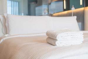 white shower towel on bed photo