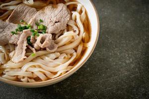 homemade udon noodles with pork in soy or shoyu soup photo