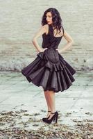 mujer, modelo de moda, con vestido negro con pelo rizado