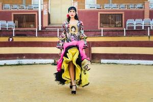 Woman, model of fashion, wearing a dress in a bullring photo