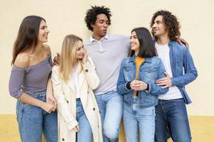 Grupo multiétnico de amigos posando mientras se divierten y ríen juntos