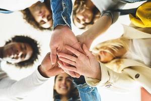 manos de un grupo multiétnico de amigos se unieron como muestra de apoyo y trabajo en equipo. foto