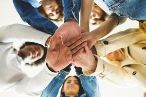 Hands of a multi-ethnic group of friends joined together as a sign of support and teamwork. photo