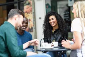 Multiracial group of four friends having a coffee together