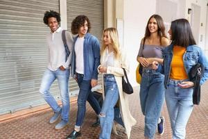 Multi-ethnic group of friends walking together on the street. photo