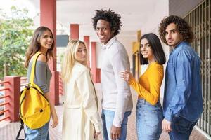 Group of beautiful friends of different ethnic having fun together in the street. photo