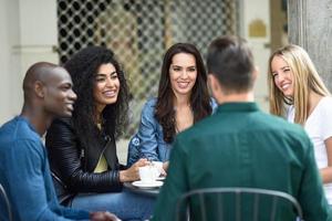 grupo multirracial de cinco amigos tomando un café juntos foto