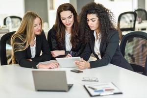 tres mujeres empresarias trabajando juntas en una oficina moderna