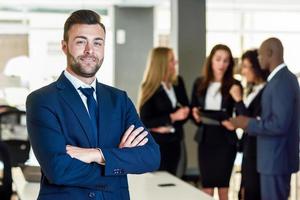 Líder empresario en la oficina moderna con empresarios que trabajan en segundo plano. foto