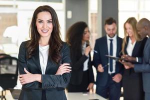 Businesswoman leader in modern office with businesspeople working at background photo