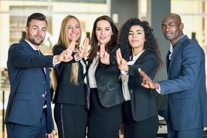 Group of businesspeople with thumbs up gesture in modern office. photo