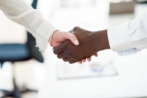 Black businessman shaking hands with a caucasian businesswoman photo