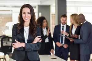 Businesswoman leader in modern office with businesspeople working at background photo